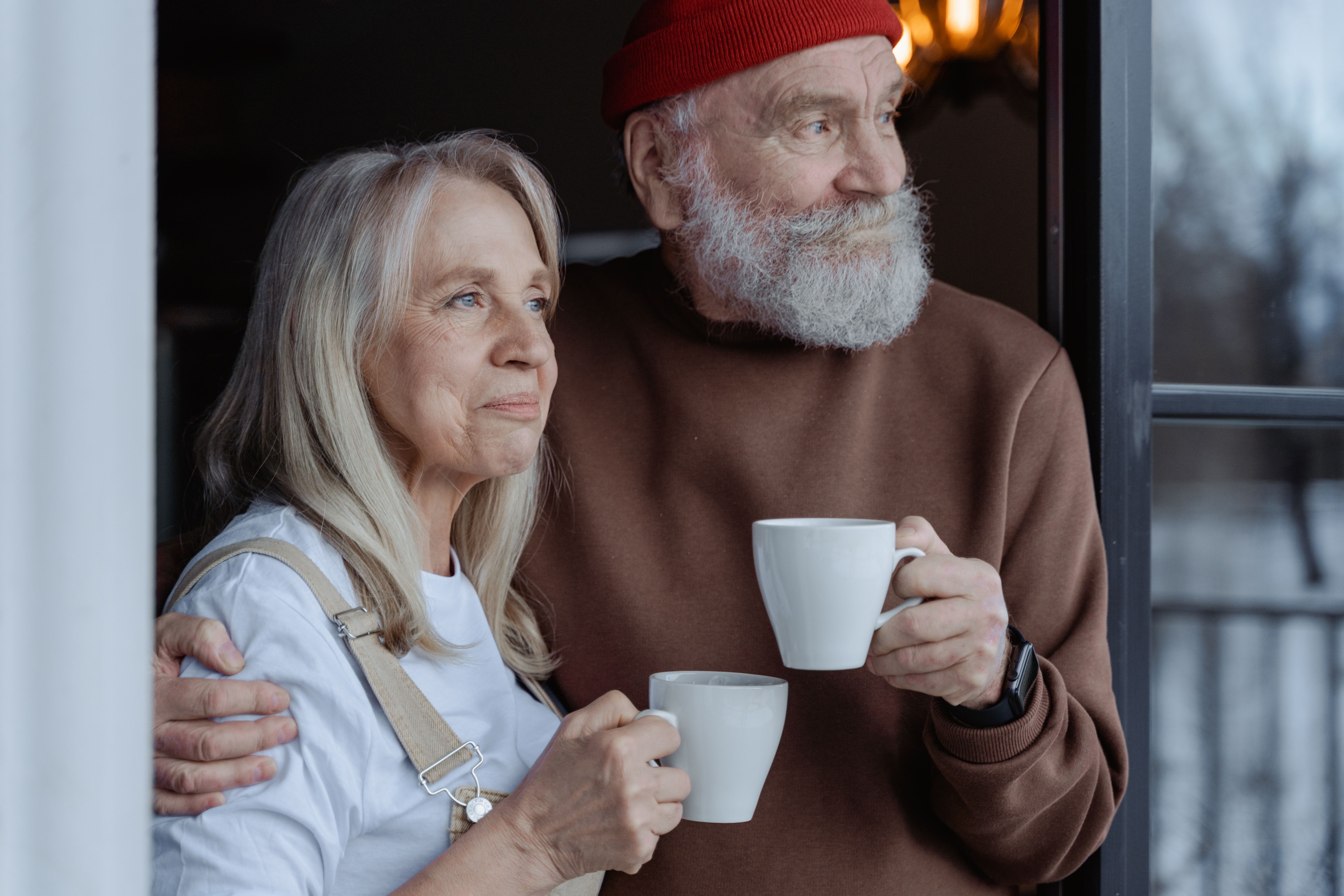 Un couple de seniors partage un moment convivial autour d'une table basse dans leur salon